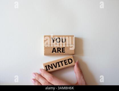 Symbol „Sie sind eingeladen“. Holzblöcke mit Worten, die Sie eingeladen sind. Schöner weißer Hintergrund. Geschäftsmann Hand. Business und Sie sind eingeladen Konzept. Stockfoto