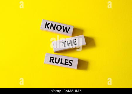 Kennen Sie das Regelsymbol. Holzblöcke mit Worten kennen die Regeln. Schöner gelber Hintergrund. Und kennen Sie das Regelkonzept. Kopierbereich. Stockfoto