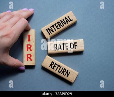 IRR - Internal Rate of Return symbol. Concept word IRR on wooden cubes. Businessman hand. Beautiful grey background. Business and IRR concept. Copy sp Stockfoto