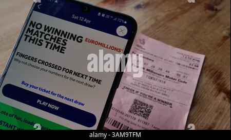 Ein Lottospieler prüft sein Lottoticket in der National Lottery App und stellt fest, dass er keine Gewinnspiele hat Stockfoto