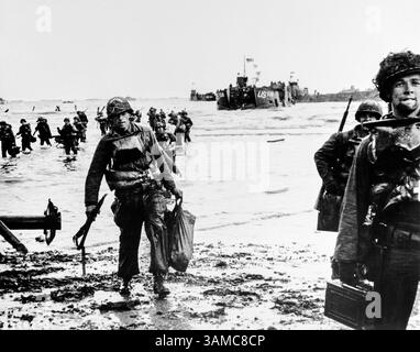 Amerikanische Angriffstruppen, die komplette Ausrüstung tragen, auf den Strand ziehen, Landeboot Jam Harbour im Hintergrund, Omaha Beach, Normandie, Frankreich, Signal Corps der US-Armee, 6. Juni 1944 Stockfoto