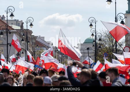 Die Anhänger schwenken polnische Nationalflaggen und schreien während der Kundgebung Slogans. In Warschau fand ein marsch zum 1000. Jahrestag des polnischen Königreichs und zum 500. Jahrestag der preußischen Hommage statt. Tausende von Teilnehmern, viele mit weißen und roten Fahnen und Bannern, gingen durch die Straßen und skandierten Slogans wie „Republik“ und „Don't Fear Tusk“. Gegen Mittag nahm Jaroslaw Kaczynski an der Veranstaltung Teil, wie zuvor angekündigt. Um 14:00 Uhr sprach Karol Nawrocki, der Präsidentschaftskandidat, der von der Partei Recht und Gerechtigkeit (PiS) unterstützt wurde, an die Menge am Castle Square, die Gehör hatte Stockfoto