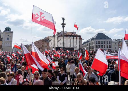 Die Anhänger schwenken polnische Nationalflaggen und schreien während der Kundgebung Slogans. In Warschau fand ein marsch zum 1000. Jahrestag des polnischen Königreichs und zum 500. Jahrestag der preußischen Hommage statt. Tausende von Teilnehmern, viele mit weißen und roten Fahnen und Bannern, gingen durch die Straßen und skandierten Slogans wie „Republik“ und „Don't Fear Tusk“. Gegen Mittag nahm Jaroslaw Kaczynski an der Veranstaltung Teil, wie zuvor angekündigt. Um 14:00 Uhr sprach Karol Nawrocki, der Präsidentschaftskandidat, der von der Partei Recht und Gerechtigkeit (PiS) unterstützt wurde, an die Menge am Castle Square, die Gehör hatte Stockfoto
