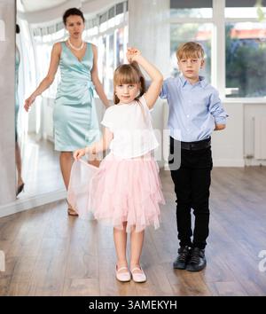 Tween Junge und Mädchen, die Walzer zu zweit in der Tanzhalle spielen Stockfoto