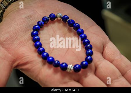 Ein Juwelier zeigt auf seiner Handfläche ein maßgeschneidertes Lapislazuli und ein silbernes Armband auf dem Großen Basar in Istanbul, Türkei Stockfoto