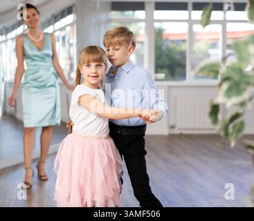 Tween Junge und Mädchen, die Walzer zu zweit in der Tanzhalle spielen Stockfoto