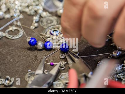 Juwelierarbeitsplatz mit Lapislazuli und Silberperlen, Werkzeugen, für ein maßgeschneidertes, einzigartiges Armband auf dem Großen Basar in Istanbul, Türkei Stockfoto