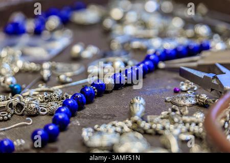 Juwelierarbeitsplatz mit Lapislazuli und Silberperlen, Werkzeugen, für ein maßgeschneidertes, einzigartiges Armband auf dem Großen Basar in Istanbul, Türkei Stockfoto