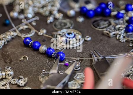 Juwelierarbeitsplatz mit Lapislazuli und Silberperlen, Werkzeugen, für ein maßgeschneidertes, einzigartiges Armband auf dem Großen Basar in Istanbul, Türkei Stockfoto