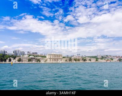 Blick auf den Dolmabahce-Palast und das Stadtbild von Istanbul vom türkisfarbenen Wasser des Bosporus unter blauem Himmel Stockfoto