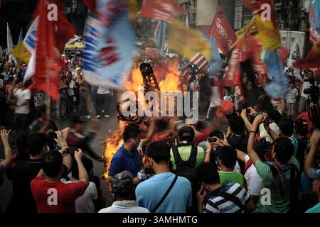 10. Dezember 2013 - Manila, Philippinen - Demonstranten tanzen um ein brennendes Bildnis, das Onkel Sam und Präsident Aquino während einer Demonstration zum Internationalen Tag der Menschenrechte vor dem Präsidentenpalast in Manila, Philippinen, am 10. Dezember 2013 darstellt. Die Demonstranten feierten den Internationalen Tag der Menschenrechte mit Protesten, die die Regierung von Präsident Aquino für Menschenrechtsverletzungen, einschließlich angeblicher außerplanmäßiger Morde, illegaler Festnahmen und der Behinderung der Existenzgrundlage der Armen während seiner Präsidentschaft, zur Rechenschaft zogen. (Bild: © Ezra Acayan/ZUMAPRESS.com) Stockfoto