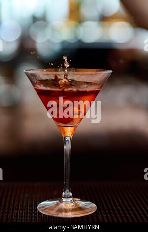 Cocktail in einem Martini-Glas mit Spritzern auf einer Bar Stockfoto
