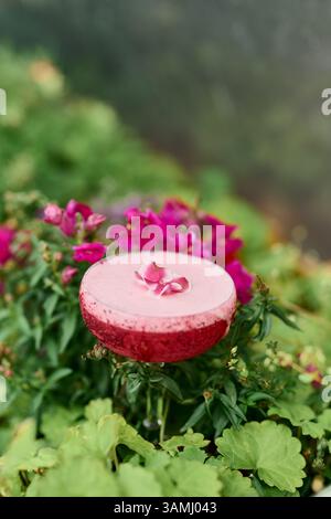 Erdbeer-Margarita-Cocktail in einem Glas auf einem Hintergrund aus rosa Blumen. Stockfoto