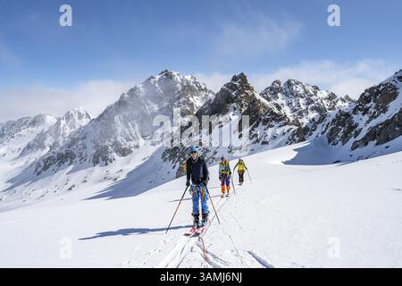 Skitourer mit Seil, Seilteam auf dem Gletscher Vadret da Porchabella beim Aufstieg zum Gipfel des Piz Kesch, Berglandschaft im Winter, alpines To Stockfoto