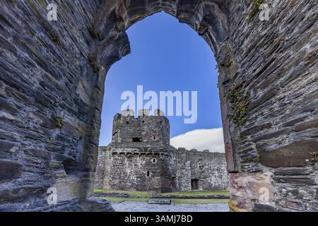 Conwy Castle, Blick durch eine bogenförmige Öffnung in der Burgmauer auf den Turm der mittelalterlichen Burg mit blauem Himmel, Conwy, Wales, Großbritannien Stockfoto