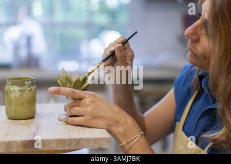 Nahaufnahme eines nachdenklichen Künstlers, der in Ton und Kreativität eingetaucht ist Stockfoto