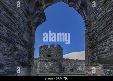 Conwy Castle, Blick durch eine bogenförmige Öffnung in der Burgmauer auf den Turm der mittelalterlichen Burg mit blauem Himmel, Conwy, Wales, Großbritannien Stockfoto