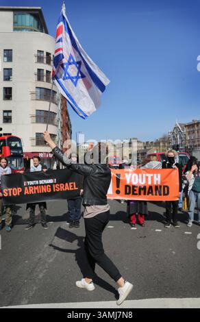 London, Großbritannien. April 2025. Ein israelischer Unterstützer, der israelische und Gewerkschaftsflaggen trägt, konfrontiert die Aktivisten mit Spruchbändern aus der Youth Demand, die die Farringdon Road blockieren. Sie blockieren Straßen in Zentral-London, um die Notlage der palästinensischen Bevölkerung in Gaza und im Westjordanland und die Komplizenschaft der britischen Regierung in ihrer Sicht mit dem weiteren Export von Waffen aus Großbritannien nach Israel und dem Einsatz von RAF-Anerkennungsflügen über Gaza hervorzuheben. Sie fordern von der britischen Regierung eine Vollstreckung Stockfoto