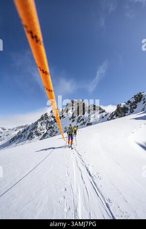 Skitourer mit Seil, Seilteam auf dem Gletscher Vadret da Porchabella beim Aufstieg zum Gipfel des Piz Kesch, Berglandschaft im Winter, alpines To Stockfoto