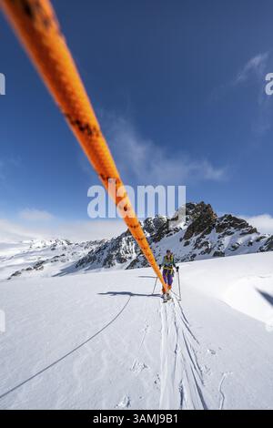 Skitourer mit Seil, Seilteam auf dem Gletscher Vadret da Porchabella beim Aufstieg zum Gipfel des Piz Kesch, Berglandschaft im Winter, alpines To Stockfoto