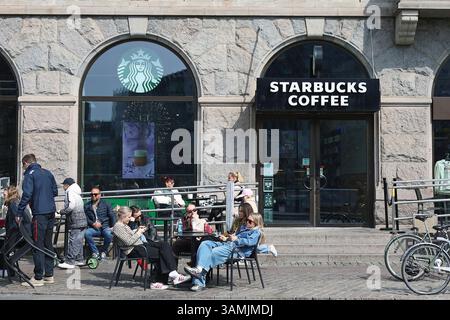 Personen, die vor einem Starbucks-Café auf dem Kopenhagener Rathausplatz (Rådhuspladsen) sitzen Stockfoto