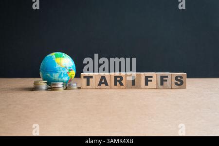 Globus mit Münzen und Botschaft, Zölle auf quadratischen Holzblöcken. Stockfoto