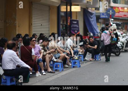 Hanoi, Vietnam, 12. April 2025. Touristen ruhen sich am 12. April 2025 auf Stühlen entlang der Straße in Hanoi, Vietnam aus. Vietnam wird die erste Station der bevorstehenden Staatsbesuche des chinesischen Präsidenten Xi Jinping in drei südostasiatischen Ländern sein. Quelle: Sheng Jiapeng/China News Service/Alamy Live News Stockfoto