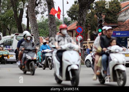 Hanoi, Vietnam, 13. April 2025. Die Nationalflaggen Chinas und Vietnams flattern auf den Laternenpfosten, während die Bewohner am 13. April 2025 in Hanoi, Vietnam, auf der Straße fahren. Vietnam wird die erste Station der bevorstehenden Staatsbesuche des chinesischen Präsidenten Xi Jinping in drei südostasiatischen Ländern sein. Quelle: Sheng Jiapeng/China News Service/Alamy Live News Stockfoto