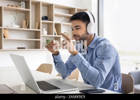 Junge Geschäftsleute tragen Ohrhörer kommunizieren per Video über Laptop Stockfoto