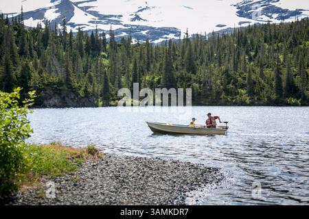 Vater und Sohn fahren in einem Fischerboot auf dem Lower Paradise Lake in den Chugach Mountains der Kenai-Halbinsel, Alaska. Stockfoto