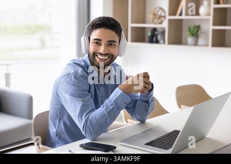 Lächelnder junger Mann mit Kopfhörern Kundenbetreuer am Arbeitsplatz Stockfoto