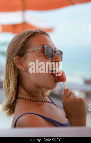 Porträt einer glücklichen Frau, die Eis isst Stockfoto