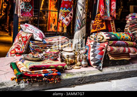 Auf einer Straße in Beyoğlu, einem historischen Viertel, das für seine Kunsthandwerksläden bekannt ist, werden lebhafte türkische Teppiche ausgestellt. Istanbul, Türkei Stockfoto