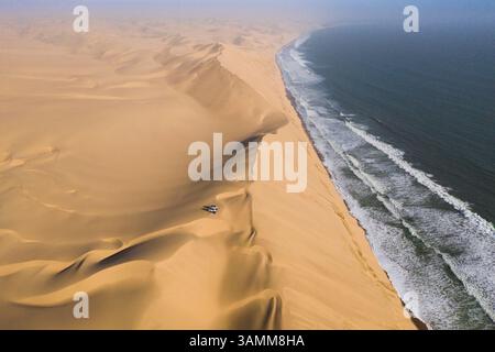 Aus der Vogelperspektive von zwei Geländejeeps, die auf den Sanddünen entlang der Küste in der Nähe von Walvis Bay, Namibia, geparkt sind. Stockfoto