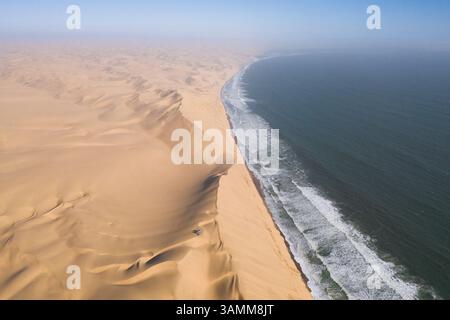 Aus der Vogelperspektive von zwei Geländejeeps, die auf den Sanddünen entlang der Küste in der Nähe von Walvis Bay, Namibia, geparkt sind. Stockfoto
