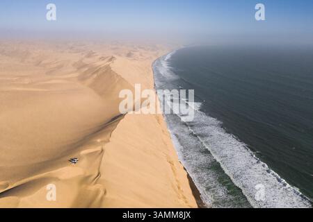 Aus der Vogelperspektive von zwei Geländejeeps, die auf den Sanddünen entlang der Küste in der Nähe von Walvis Bay, Namibia, geparkt sind. Stockfoto