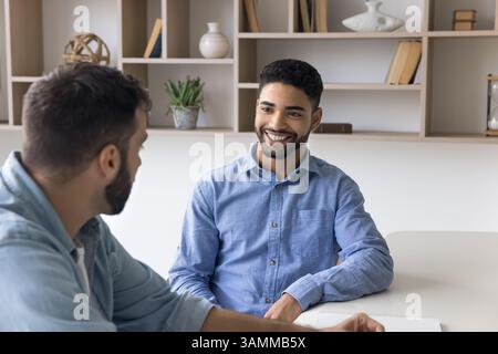 Zwei Geschäftsleute, die sich zwanglos am Schreibtisch unterhalten Stockfoto