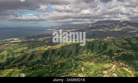 Aus der Vogelperspektive auf die wunderschöne Küste farbenfrohe Berge mit schweren Wolken vor einem Sturm in Marbella, Spanien Stockfoto