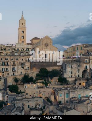 Blick aus der Vogelperspektive auf den wunderschönen Duomo di Matera und historische Steinbauten in der Altstadt bei Sonnenuntergang, Matera, Italien. Stockfoto