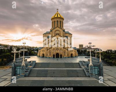 Aus der Vogelperspektive auf die majestätische Dreifaltigkeitskirche mit ihrer goldenen Kuppel bei Sonnenuntergang, Avlabari, Tiflis, Georgien. Stockfoto
