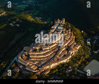 Blick aus der Vogelperspektive auf die malerische mittelalterliche Stadt mit historischer Architektur und bezaubernden Dächern, umgeben von üppigem Grün, Nocera Umbra, Italien. Stockfoto