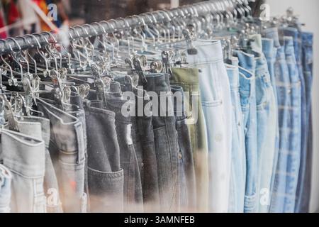 Ein Regal mit Second-Hand-Jeans auf dem Brick Lane Market in London Stockfoto