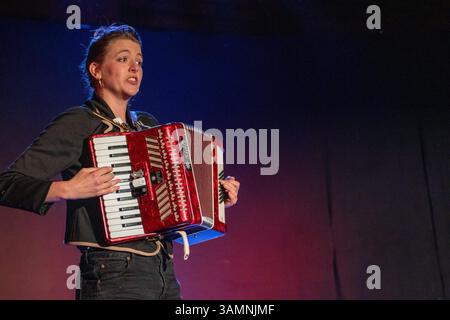 In einer Varieté-Show im Slate Barn Sweffling spielt eine junge Frau ein Stella-Klavierakkordeon und singt während ein Bühnenwechsel stattfindet. Stockfoto