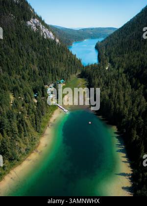Blick aus der Vogelperspektive auf den farbenfrohen und ruhigen Johnson Lake, umgeben von üppigen Wäldern und Bergen, Louis Creek, Kanada. Stockfoto