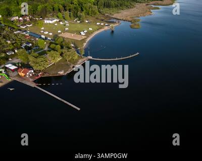 Blick aus der Vogelperspektive auf den ruhigen See Zdaszynskie mit Piers und Campingplatz, Zbaszyn, Polen. Stockfoto