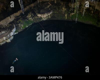 Aus der Vogelperspektive auf die ruhige Cenote mit einer Person schwimmen, Valladolid, Yucatan, Mexiko. Stockfoto
