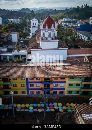Blick aus der Vogelperspektive auf das lebendige Guatape mit farbenfrohen Gebäuden, Dächern und Kirche, Antioquia, Kolumbien. Stockfoto