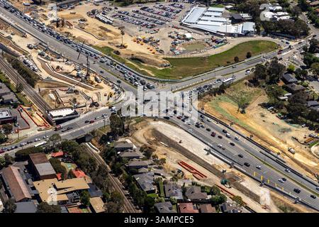 Luftaufnahme der städtischen Kreuzung mit Verkehr und Fahrzeugen umgeben von Gebäuden, Watsonia, Victoria, Australien. Stockfoto