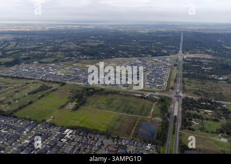 Aus der Vogelperspektive der Wohnsiedlung mit Straßen und Feldern, umgeben von Grün, Cranbourne West, Australien. Stockfoto