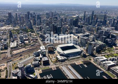 Blick aus der Vogelperspektive auf das Stadion und die Skyline der Stadt mit der Uferpromenade bei sonnigem Wetter, Docklands, Melbourne, Australien. Stockfoto